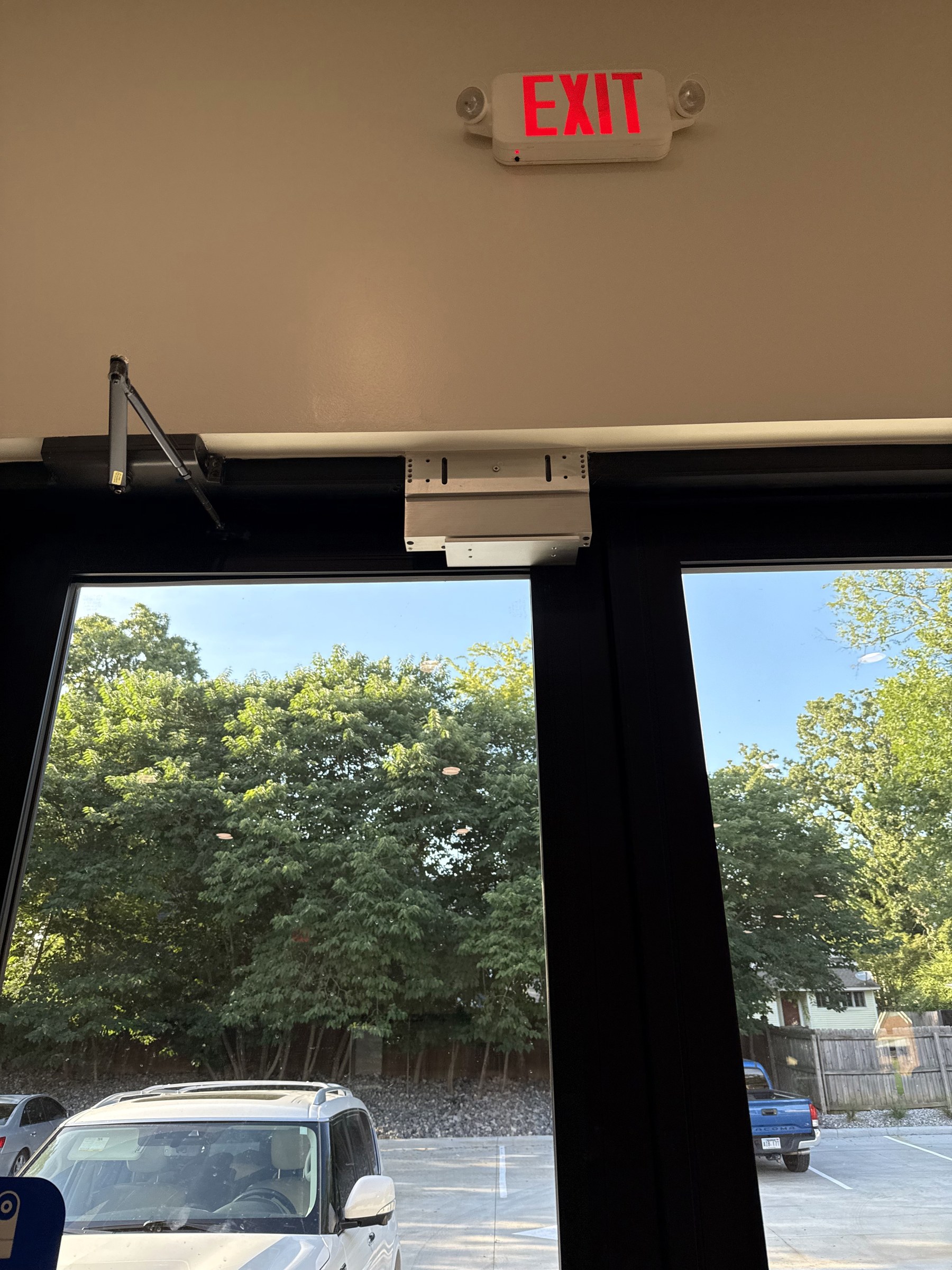 Door access hardware and maglock installed on a glass storefront entry door